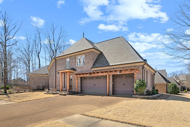 view of front of property featuring concrete driveway, brick siding, roof with shingles, and an attached garage