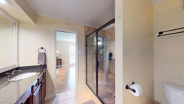 full bathroom featuring crown molding, toilet, a stall shower, vanity, and tile patterned flooring