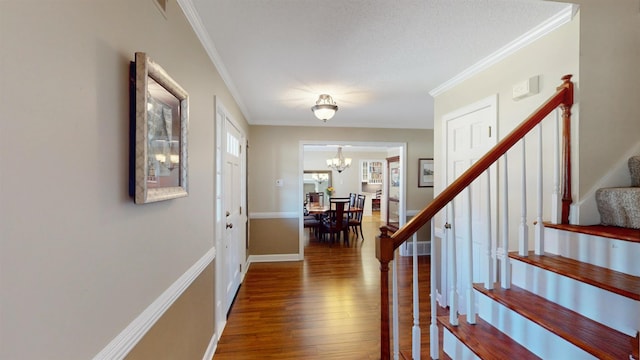 foyer featuring ornamental molding, stairway, an inviting chandelier, and wood finished floors