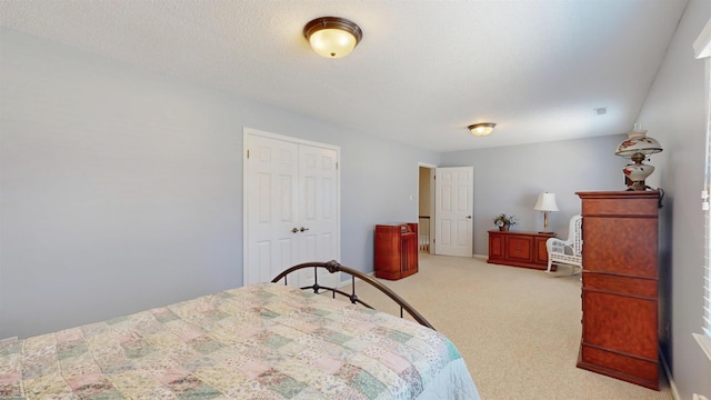 carpeted bedroom with a textured ceiling and a closet