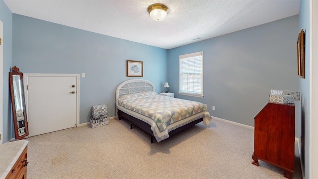 bedroom with a textured ceiling, baseboards, and carpet flooring