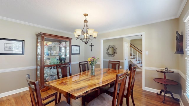 dining room featuring crown molding, baseboards, and wood finished floors