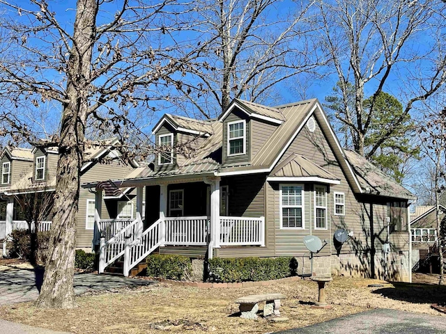 cape cod-style house with covered porch and metal roof