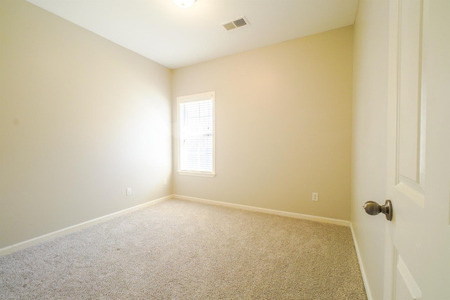 empty room with carpet floors, visible vents, and baseboards