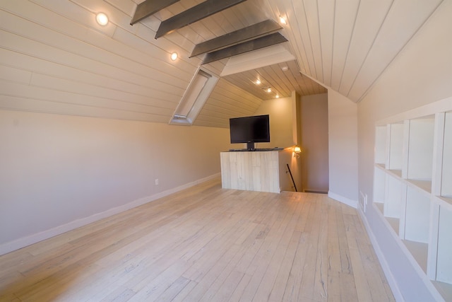 unfurnished living room featuring lofted ceiling with beams, light wood-type flooring, wood ceiling, and baseboards