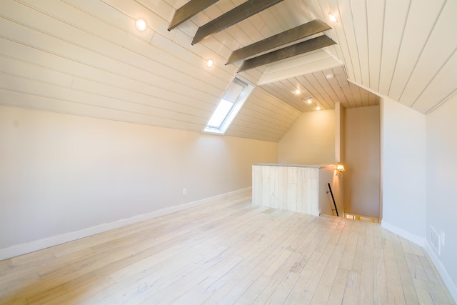 additional living space featuring vaulted ceiling with skylight, wood-type flooring, wood ceiling, and baseboards