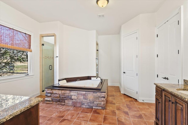 full bathroom featuring a garden tub, a stall shower, vanity, baseboards, and tile patterned floors