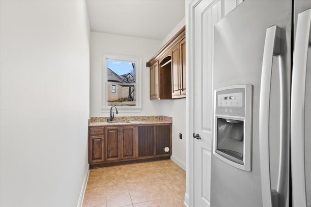 hallway featuring a sink and baseboards