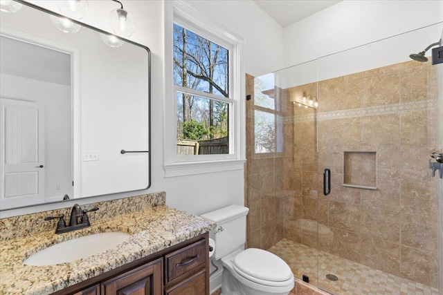 bathroom featuring a stall shower, vanity, and toilet