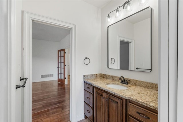 bathroom with visible vents, vanity, and wood finished floors