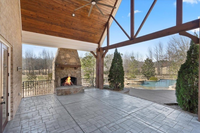 view of patio with a pool with connected hot tub, an outdoor stone fireplace, and a ceiling fan