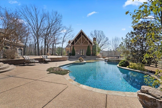 view of pool featuring an outbuilding, a patio, a storage structure, and a pool with connected hot tub