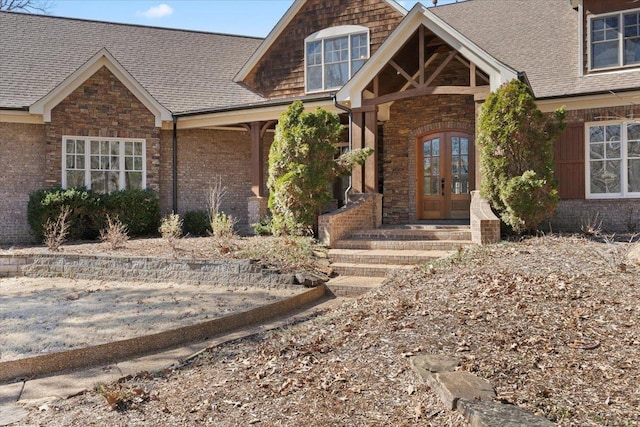 view of front of home with french doors and roof with shingles