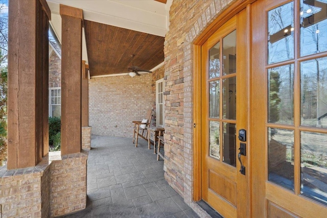 property entrance with stone siding and ceiling fan