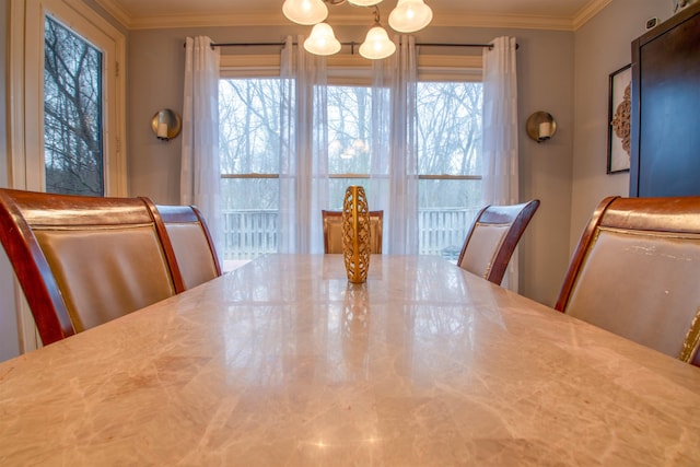 dining space with ornamental molding, a healthy amount of sunlight, and a notable chandelier