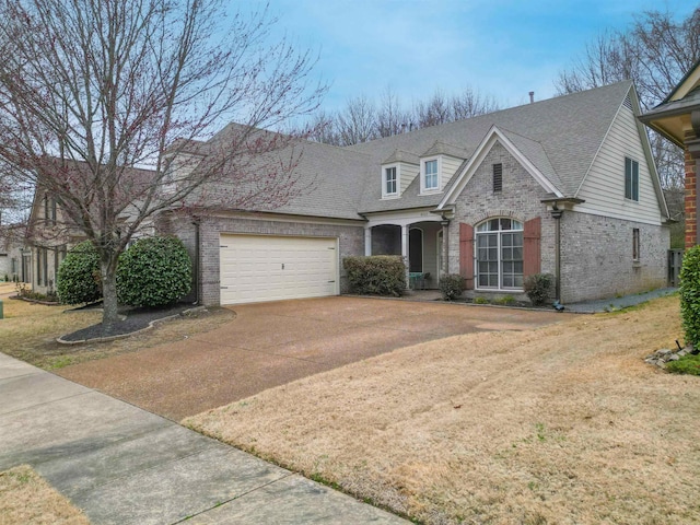 view of front of property with a garage, a shingled roof, concrete driveway, and brick siding