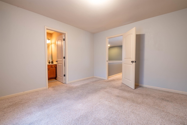 spare room with baseboards and light colored carpet