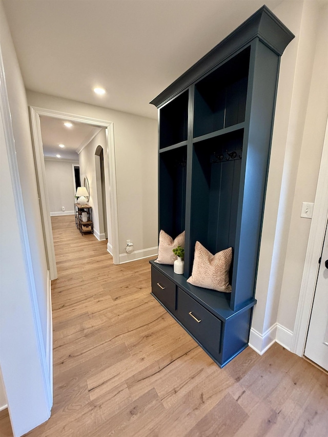 mudroom with arched walkways, light wood finished floors, recessed lighting, and baseboards