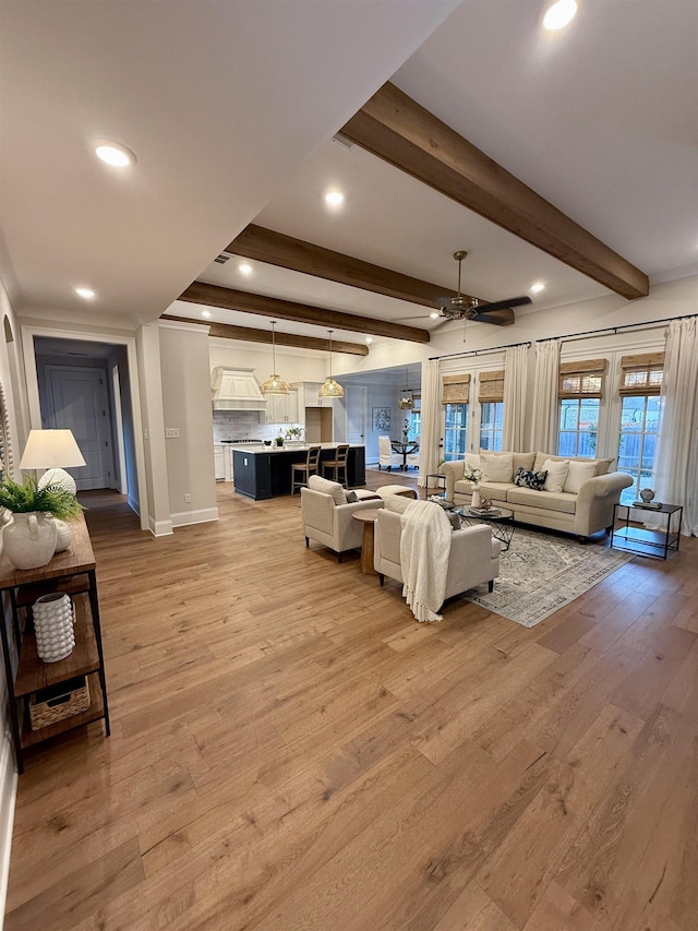 living room with light wood-type flooring, ceiling fan, beam ceiling, and recessed lighting