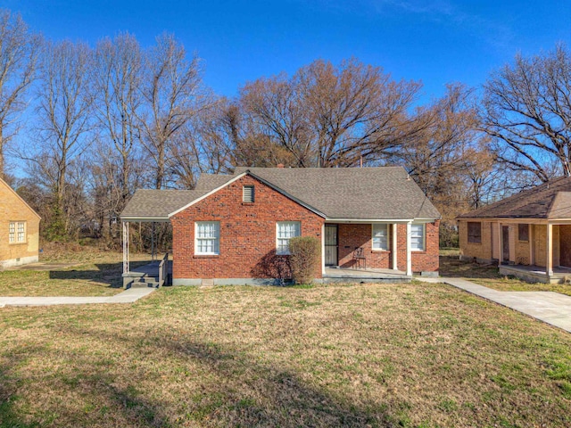 view of front of property featuring a porch, a front yard, brick siding, and a shingled roof