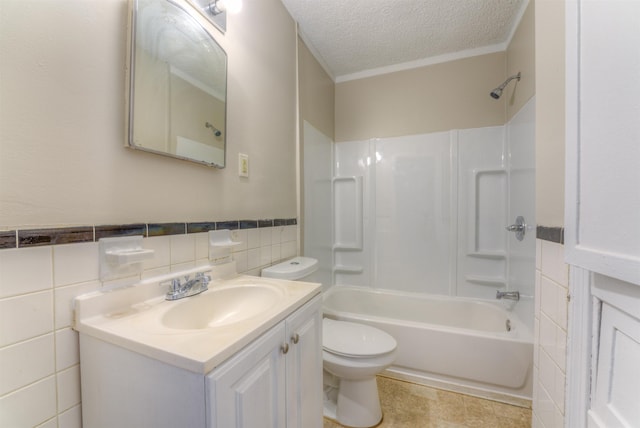 full bath with toilet, shower / bathtub combination, a textured ceiling, vanity, and tile walls