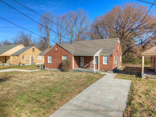 bungalow-style home featuring a front yard, covered porch, brick siding, and roof with shingles