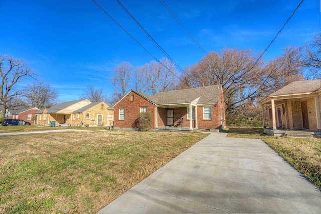 view of front facade featuring a porch, a front lawn, and brick siding