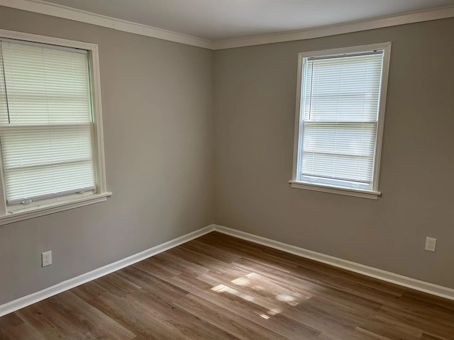 unfurnished room featuring crown molding, wood finished floors, and baseboards