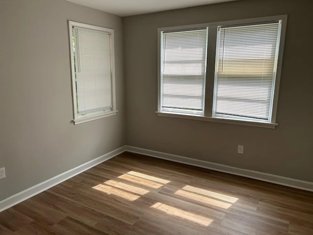 unfurnished room featuring baseboards and a wealth of natural light