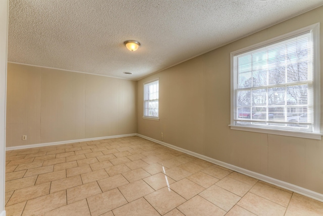 tiled spare room featuring a textured ceiling