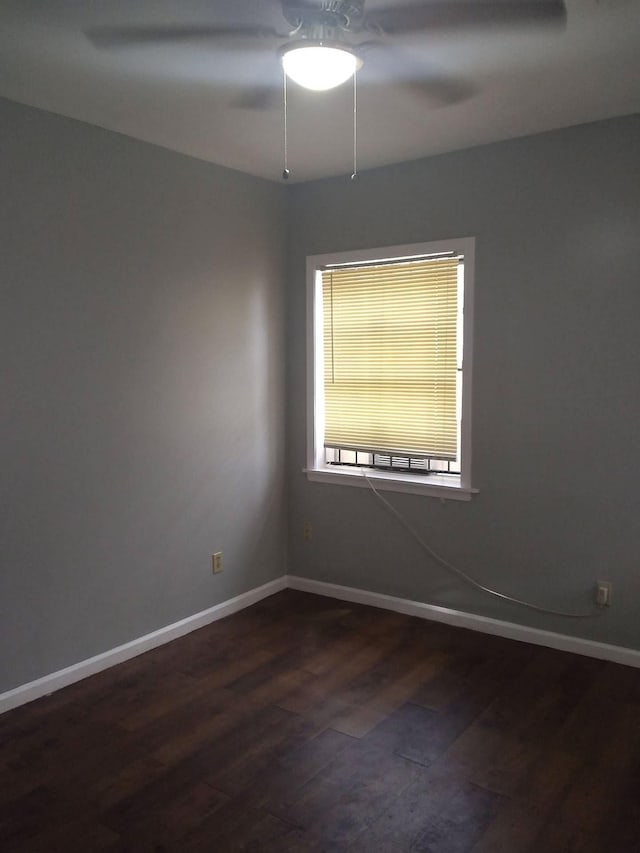 empty room featuring dark wood finished floors and baseboards