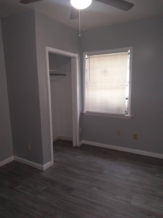 unfurnished bedroom featuring ceiling fan, a closet, wood finished floors, and baseboards