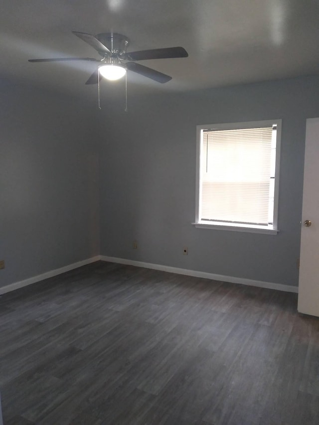 unfurnished room with dark wood-style flooring, ceiling fan, and baseboards