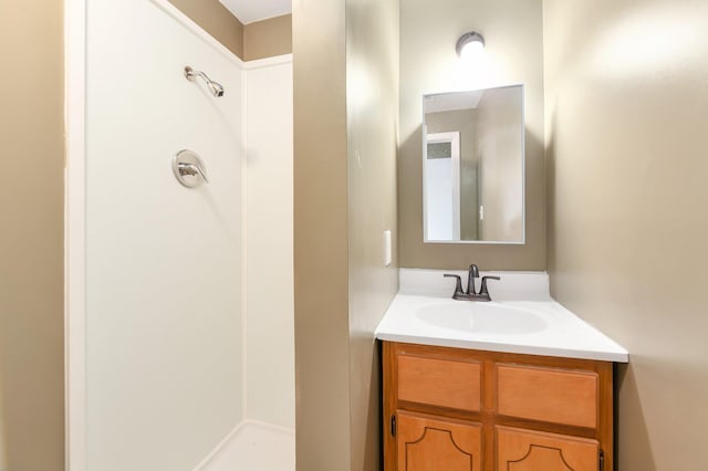 bathroom featuring a shower and vanity