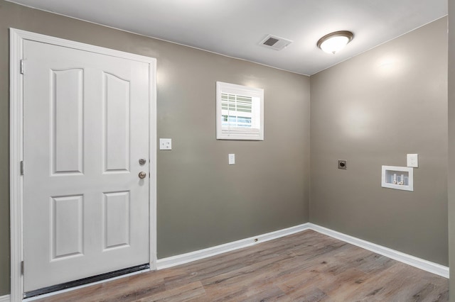 clothes washing area with visible vents, light wood-style flooring, electric dryer hookup, laundry area, and baseboards