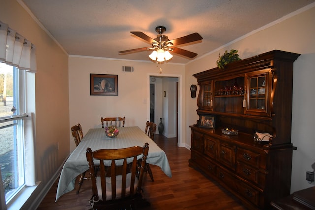 dining space with baseboards, visible vents, a ceiling fan, wood finished floors, and crown molding