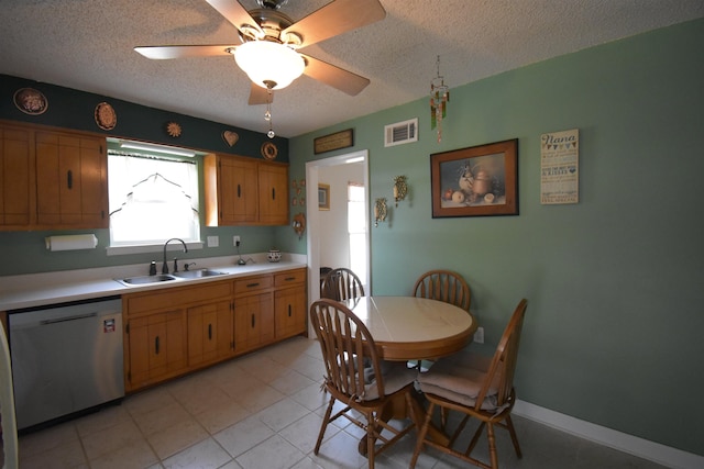 kitchen featuring light countertops, visible vents, a sink, a textured ceiling, and dishwasher