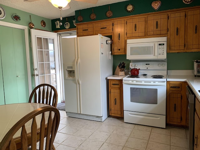 kitchen featuring a textured ceiling, ceiling fan, white appliances, light countertops, and brown cabinets