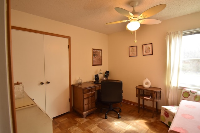 office area with ceiling fan, a textured ceiling, and baseboards