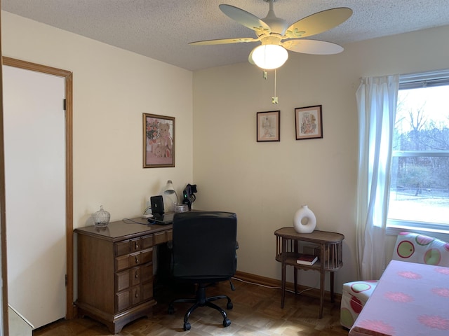 office space featuring baseboards, a ceiling fan, and a textured ceiling