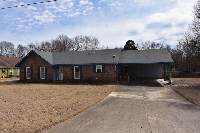 ranch-style house with brick siding, driveway, central AC, and roof with shingles