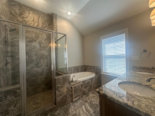 full bathroom featuring a stall shower, lofted ceiling, a sink, and a bath