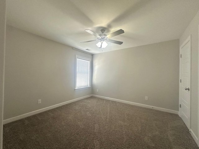 unfurnished room featuring dark colored carpet, a ceiling fan, visible vents, and baseboards