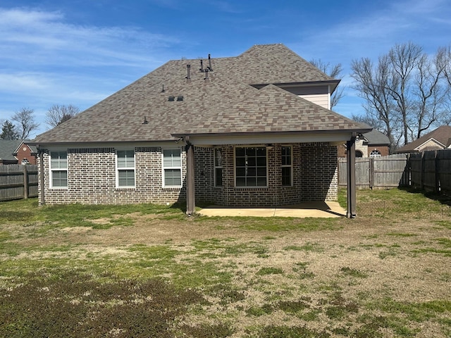 back of property with a patio area, a fenced backyard, a shingled roof, and brick siding