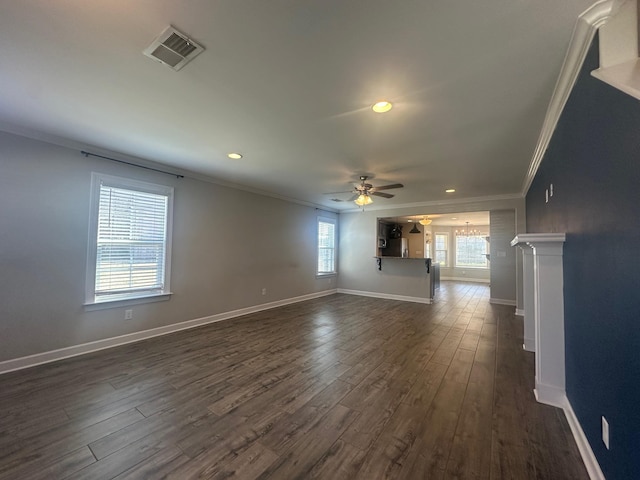 unfurnished living room with ceiling fan, dark wood-style flooring, visible vents, baseboards, and ornamental molding