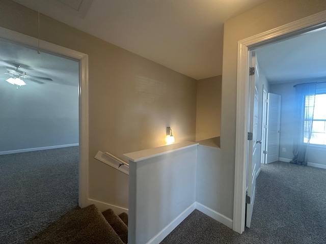 hall with carpet, baseboards, and an upstairs landing