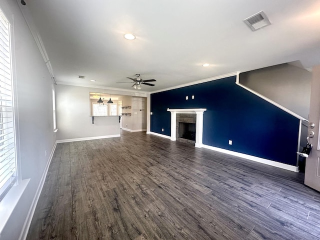 unfurnished living room featuring visible vents, crown molding, a fireplace, and ceiling fan