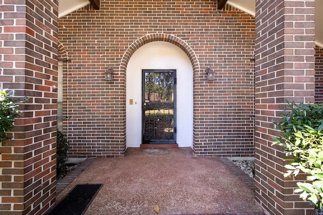 doorway to property featuring brick siding