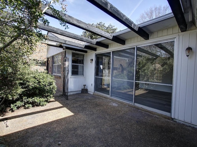 doorway to property with a patio area and board and batten siding