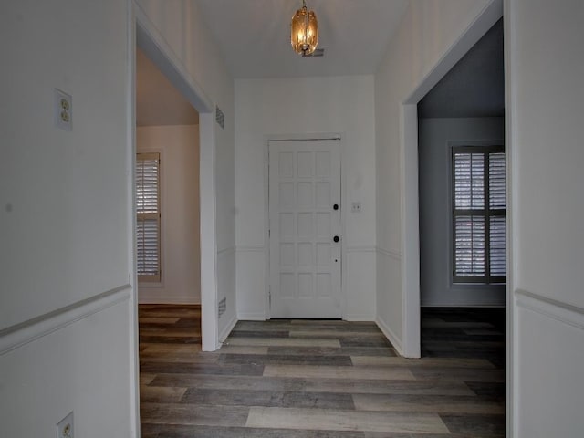 foyer featuring baseboards, visible vents, and wood finished floors